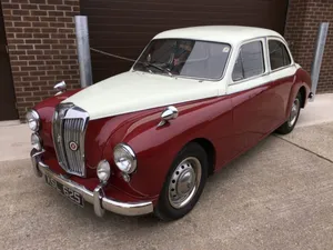 Caption: Classically Styled Mg Magnette Sedan Against A Serene Landscape Wallpaper