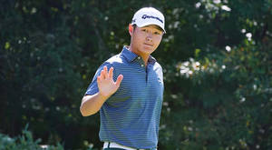 Caption: Danny Lee Smiling And Waving At The Camera Wallpaper