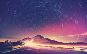 Caption: Dawn Break On A Paved Road Wallpaper