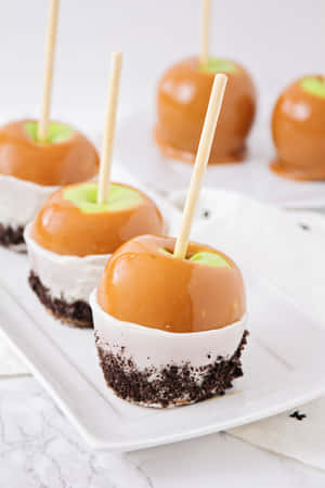 Caption: Delicious Caramel Apples On Rustic Wooden Table Wallpaper