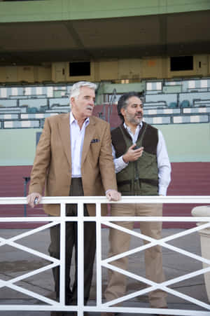 Caption: Dennis Farina Striking A Pose During A Photoshoot Wallpaper