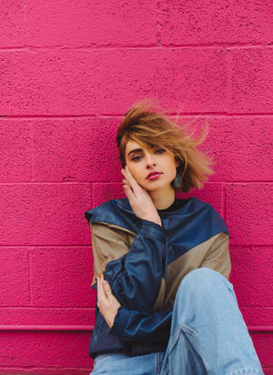 Caption: Edgy Cool Girl Leaning Against Graffiti Wall Wallpaper