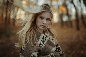 Caption: Elegant Blonde Woman Embracing Fall Fashion Wallpaper