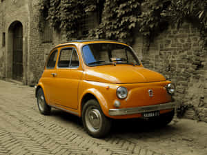 Caption: Elegant Fiat Cinquecento In Cityscape Wallpaper