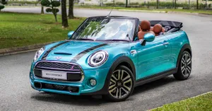 Caption: Elegant Mini Cooper Convertible Under A Dazzling Sky Wallpaper