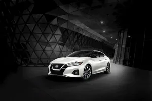Caption: Elegant Nissan Maxima In A Cityscape Wallpaper
