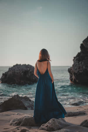 Caption: Elegant Woman In A Chic Navy Blue Dress Wallpaper