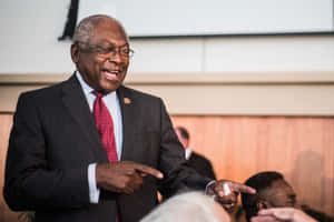 Caption: Engaging Moment Of Jim Clyburn Laughing And Pointing Wallpaper