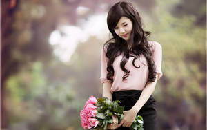 Caption: Graceful Chinese Girl Holding A Pink Bouquet Wallpaper