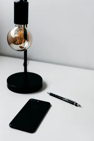 Caption: Illuminated Iphone On A Minimalist Desk Wallpaper