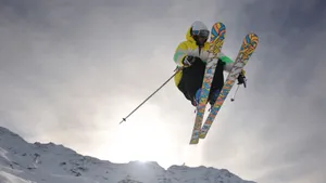Caption: Intense Action Mid-air - Ski Jumper In Motion Wallpaper