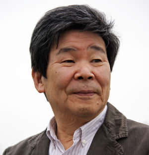 Caption: Isao Takahata Smiling In Front Of His Illustrations Wallpaper