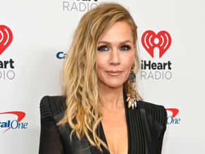 Caption: Jennie Garth Smiling Radiantly In A Photoshoot Wallpaper