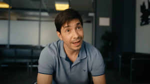 Caption: Justin Long Smiling And Posing For A Photoshoot Wallpaper
