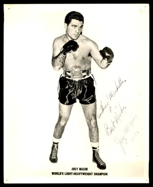 Caption: Legendary Boxing Champion Joey Maxim Signing An Autograph Wallpaper