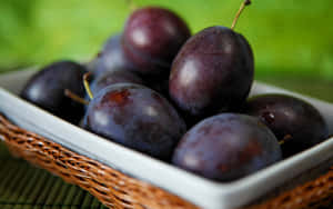 Caption: Luscious Italian Prune Plums Displayed On A Fruit Platter Wallpaper