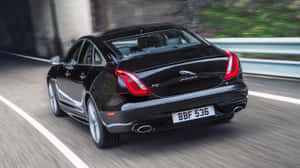 Caption: Luxurious Jaguar Xj In Motion Wallpaper