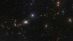 Caption: Majestic Elliptical Galaxy In Space Wallpaper