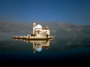 Caption: Majestic Reflection Of Our Lady Of The Rocks Islet Wallpaper