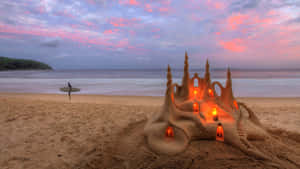 Caption: Majestic Sandcastles On A Bright, Sunny Beach Wallpaper