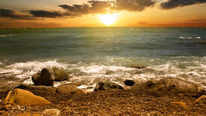 Caption: Majestic Sunset At The Beach Wallpaper