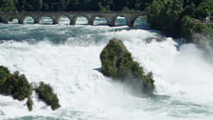 Caption: Majestic View Of Rhine Falls In Schaffhausen, Switzerland Wallpaper