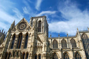 Caption: Majestic View Of York Minster Cathedral Against A Dramatic Sky Wallpaper