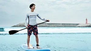 Caption: Man Paddleboarding On Crystal Clear Water Wallpaper