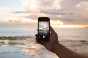 Caption: Modern Smartphone On Desk Wallpaper