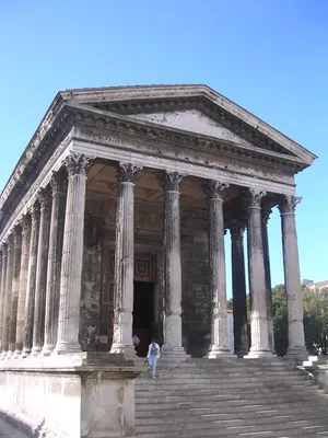 Caption: Person Ascending Steps Of The Historic Maison Carrée Wallpaper