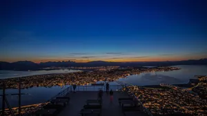 Caption: Picturesque View Of Tromso Under The Northern Lights Wallpaper
