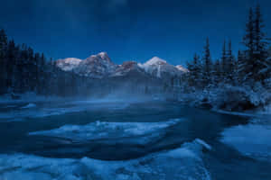 Caption: Pristine Rocky Mountains Under The Starlit Sky Wallpaper