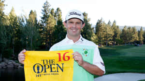 Caption: Professional Golfer Greg Chalmers Holding A Yellow Banner Wallpaper