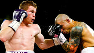 Caption: Saul 'canelo' Alvarez Delivering A Powerful Blow In A Boxing Match Wallpaper