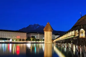 Caption: Serene Lucerne Lake With Majestic Snow-capped Mountains Wallpaper