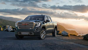 Caption: Sleek And Powerful Gmc Yukon On Mountain Road Wallpaper