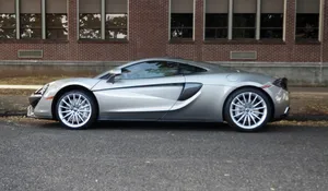 Caption: Sleek And Sporty Mclaren 570gt On The Road Wallpaper