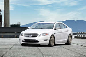 Caption: Sleek Ford Taurus On The Road Wallpaper