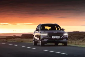 Caption: Sleek Genesis Gv70 Cruising On A Road Wallpaper