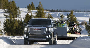 Caption: Sleek Gmc Yukon Driving Through An Urban Landscape. Wallpaper