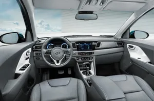 Caption: Sleek Kia Niro On A Scenic Road Wallpaper