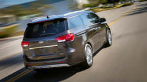 Caption: Sleek Kia Sedona On City Road Wallpaper