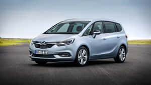 Caption: Sleek Opel Zafira Driving On A Scenic Road Wallpaper