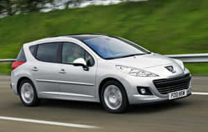 Caption: Sleek Peugeot 207 Gliding On Country Road Wallpaper