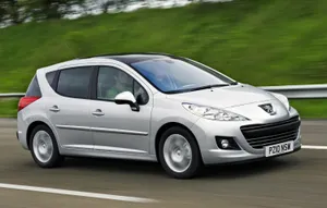 Caption: Sleek Peugeot 207 Gliding On Country Road Wallpaper