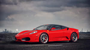 Caption: Sleek Red Ferrari F430 Cruising Down The Highway Wallpaper