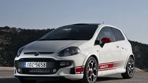 Caption: Sleek Red Fiat Punto Cruising On The Road Wallpaper