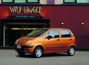 Caption: Sleek Silver Daewoo Matiz Parked On The Road Wallpaper