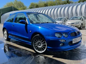 Caption: Sleek Silver Mg Zr Glinting Under A Bright Blue Sky Wallpaper