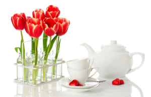 Caption: Soothing Floral Tea In Elegant Teapot And Cup Wallpaper